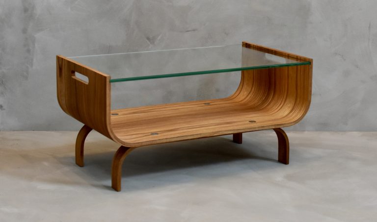 Salontafel van gebogen iepenhout met glazen blad in woonkamer